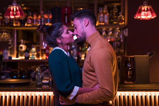 Jeune homme embrassant avec une femme charmante