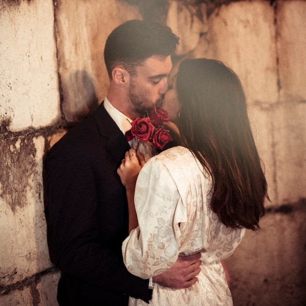 Jeune Homme Embrasse Une Femme Se Penchant Sur Le Mur