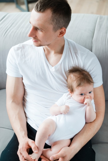 Jeune homme avec enfant en bas âge sur le canapé