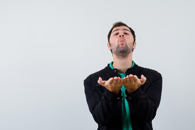 Jeune homme envoyant des baisers sur fond blanc