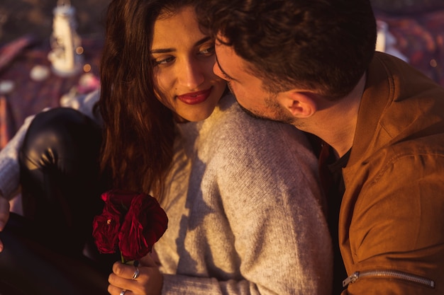 Jeune homme, étreignant femme, à, fleurs rouges