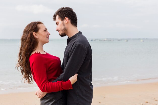 Jeune homme, étreignant femme, sur, rivage sable fin