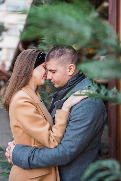 Jeune homme, étreindre, sourire, femme, dans, manteaux, dans parc