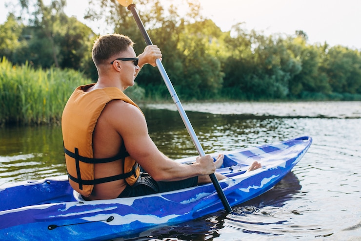 Photo gratuit jeune homme faisant du kayak sur la rivière