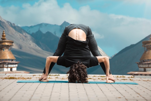 Photo gratuite jeune homme faisant du yoga dans le loft au lever du soleil