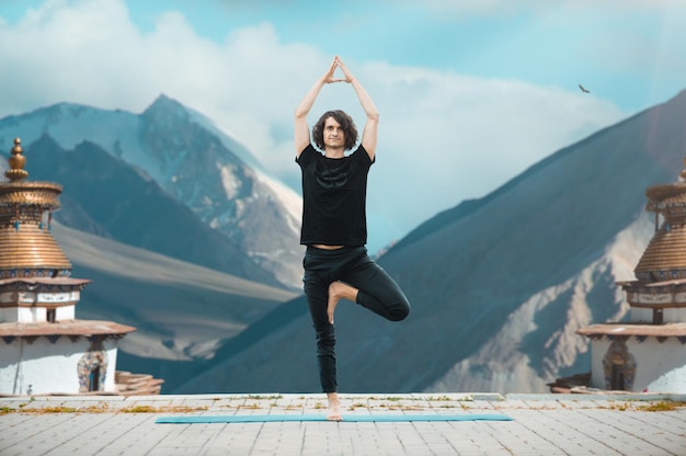 Photo gratuite jeune homme faisant du yoga dans le loft au lever du soleil