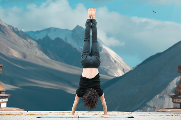 Photo gratuite jeune homme faisant du yoga dans le loft au lever du soleil