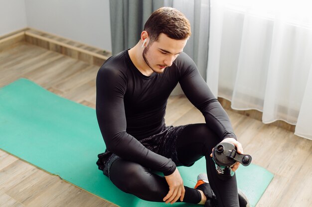 Jeune homme faisant des exercices de sport à la maison