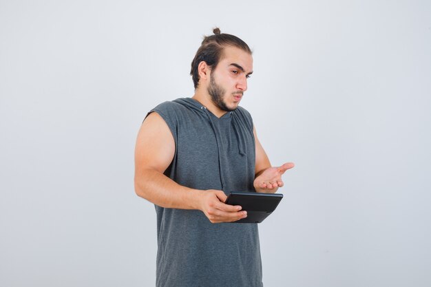 Jeune homme faisant un geste de question en sweat à capuche et à la perplexité.