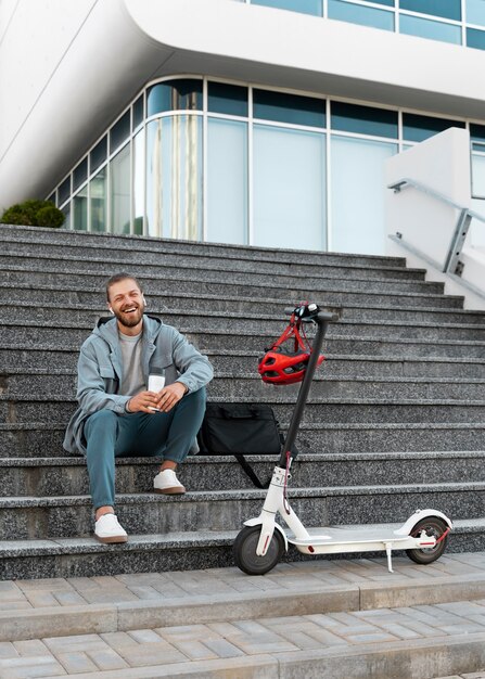 Jeune homme faisant une pause après avoir conduit son scooter