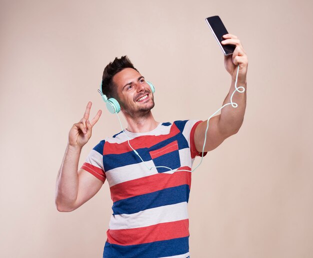 Photo gratuite jeune homme faisant selfie en studio shot