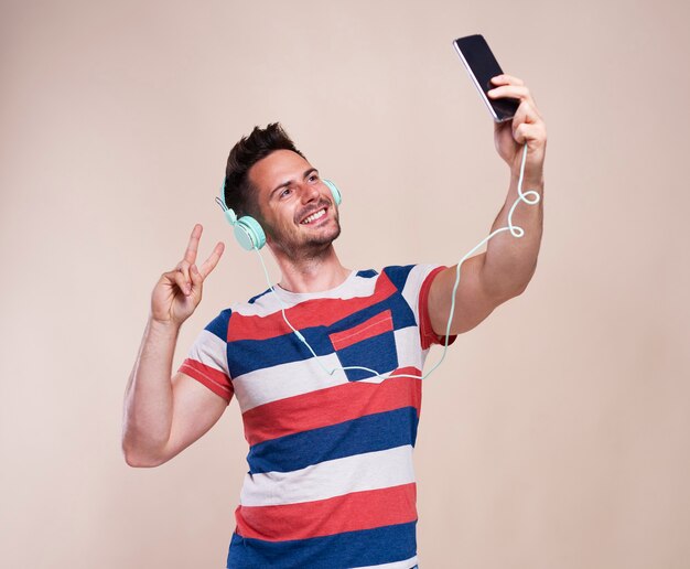 Jeune homme faisant selfie en studio shot