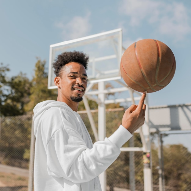 Jeune homme faisant des tours avec un ballon de basket
