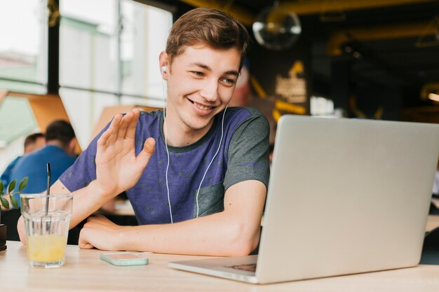 Jeune homme fait un appel vidéo sur ordinateur portable