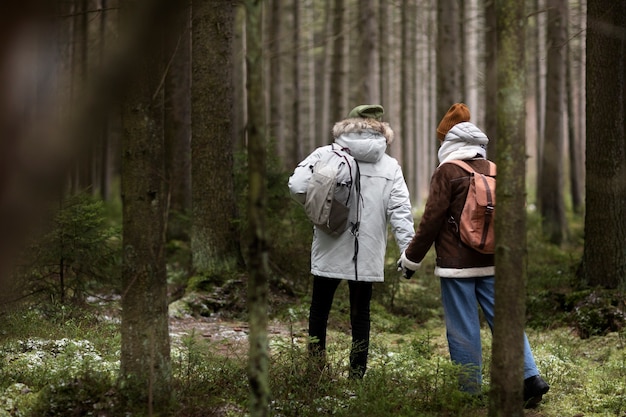 Jeune homme et femme dans une forêt ensemble pendant un voyage d'hiver