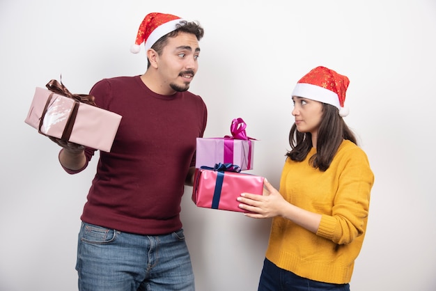 Jeune homme avec une femme posant avec des cadeaux de Noël.