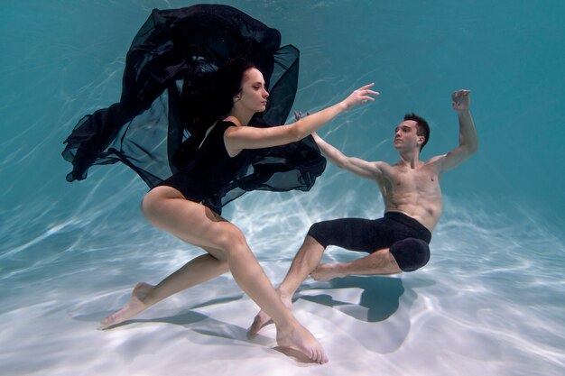 Jeune homme et femme posant ensemble sous l'eau