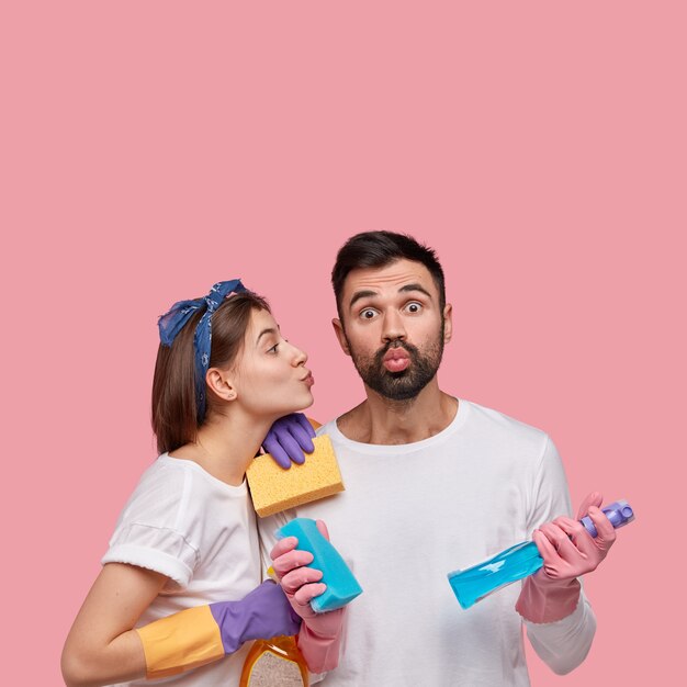 Jeune homme et femme posant avec des produits de nettoyage