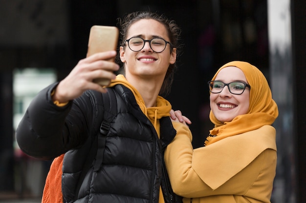 Jeune homme et femme prenant un selfie ensemble