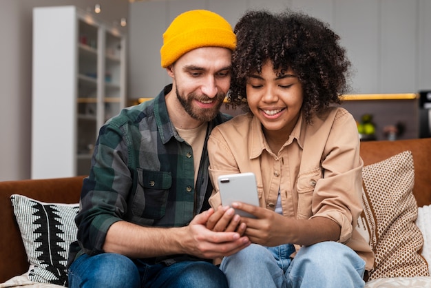 Jeune homme et femme à la recherche au téléphone