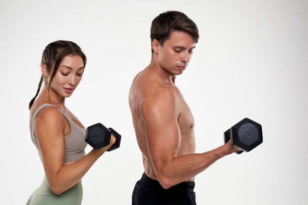 Jeune homme et femme s'entraînant ensemble pour la musculation