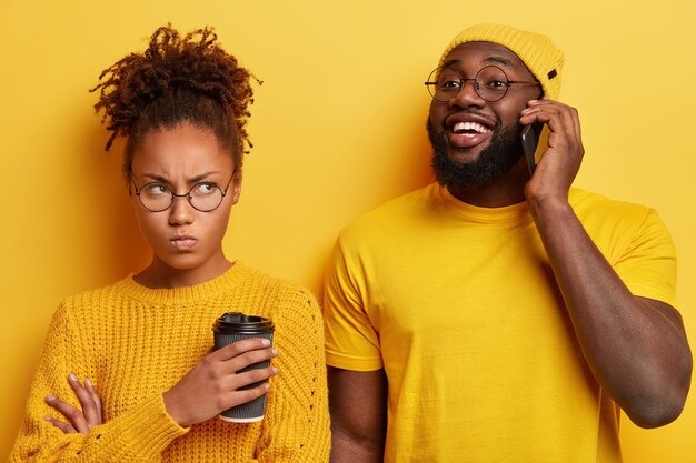 Jeune homme et femme souriant et posant