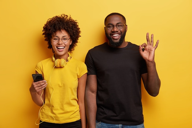 Jeune homme et femme souriant et posant