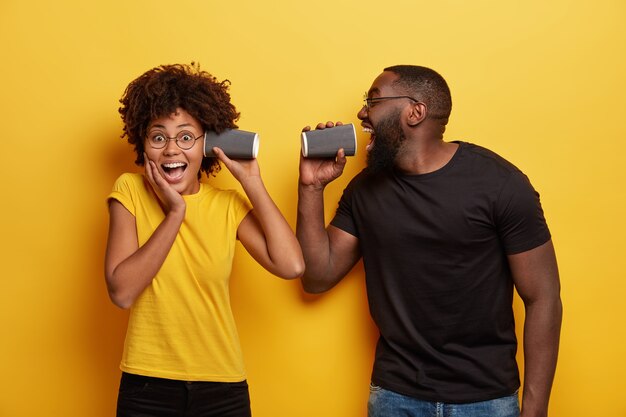 Jeune homme et femme tenant des tasses de café