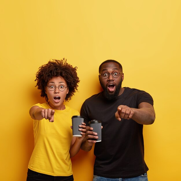 Jeune homme et femme tenant des tasses de café