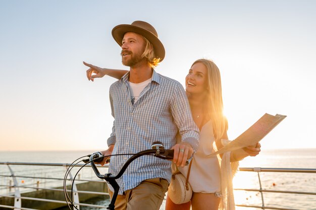 Jeune homme et femme voyageant sur des vélos tenant une carte