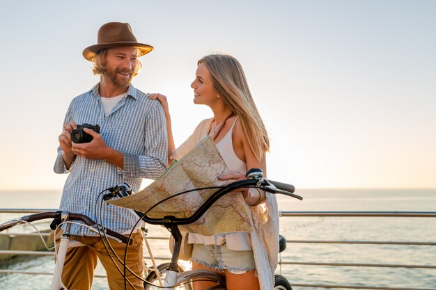 Jeune homme et femme voyageant sur des vélos tenant une carte