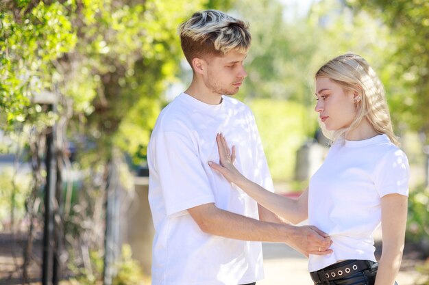 Un jeune homme et une fille se tiennent face à face et se regardent