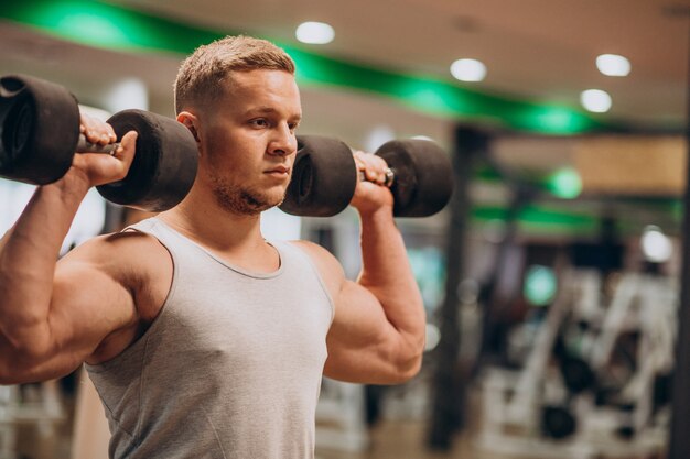 Jeune homme fort exerçant à la salle de gym