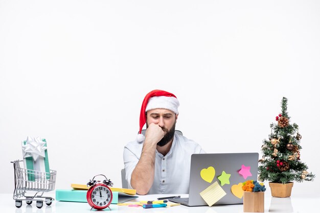 Jeune homme gai bien pensé au bureau célébrant le nouvel an ou Noël travaillant seul sur fond blanc