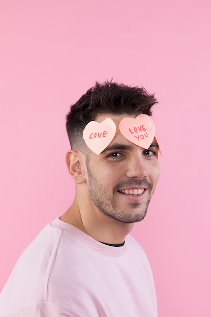 Jeune homme heureux avec des coeurs de papier sur le devant