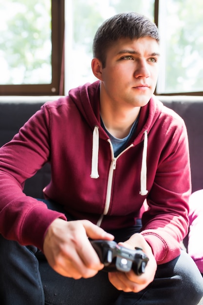 Photo gratuite jeune homme heureux en riant et en jouant à des jeux vidéo le week-end