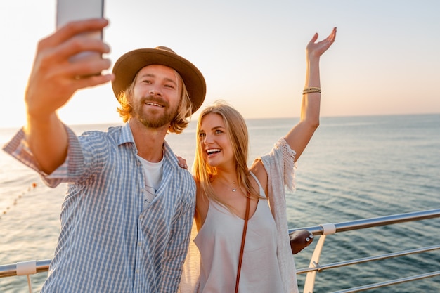 Jeune homme heureux souriant et femme voyageant sur des vélos en prenant selfie photo sur l'appareil photo du téléphone