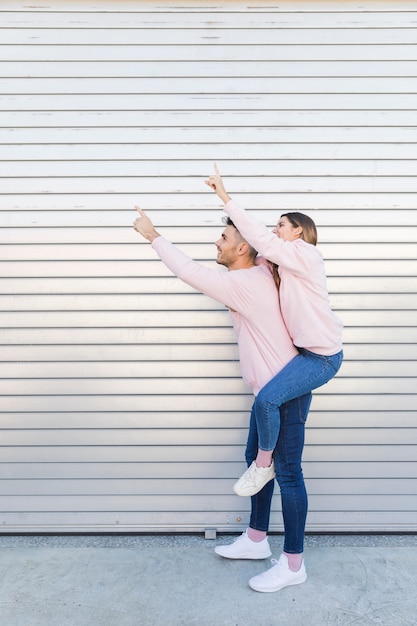 Jeune homme heureux, tenant une femme séduisante