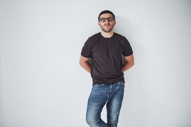 Jeune homme hipster portant des lunettes en riant joyeusement isolé sur blanc