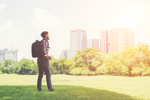 Jeune homme hipster profiter de la vue de la ville du parc, avant de passer à tr