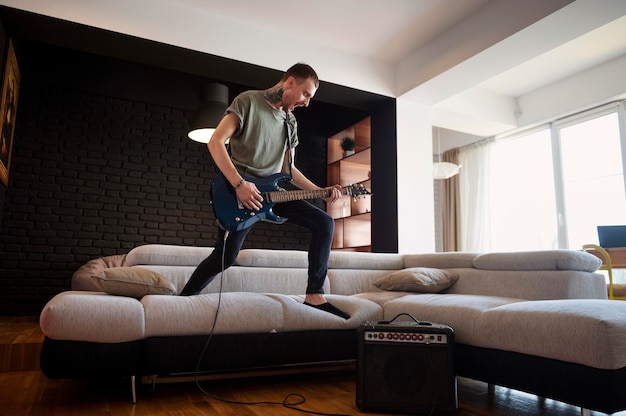 Photo gratuite jeune homme jouant de la guitare à la maison