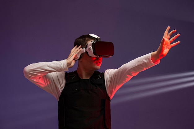 Photo gratuite jeune homme jouant à un jeu vidéo avec des lunettes de réalité virtuelle