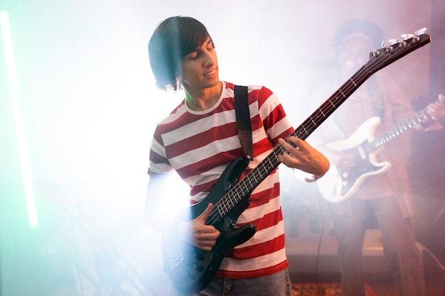 Jeune homme jouant de la musique de guitare lors d'un événement local