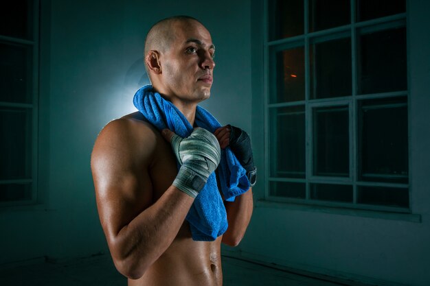 Le jeune homme kickboxing sur mur noir