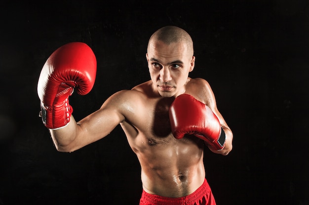 jeune homme kickboxing sur noir