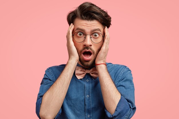 Jeune homme à lunettes rondes et noeud papillon rose