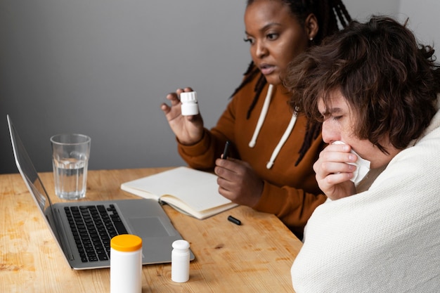 Jeune homme malade et ami ayant un appel vidéo avec un médecin