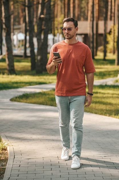 Photo gratuite jeune homme marchant dans la zone du parc