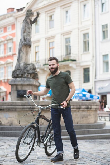Jeune homme, marche, bicyclette, devant, statue