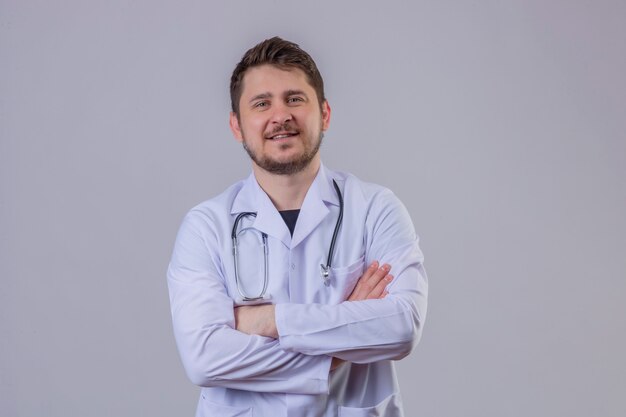 Jeune homme médecin portant blouse blanche et stéthoscope à la confiance avec les bras croisés